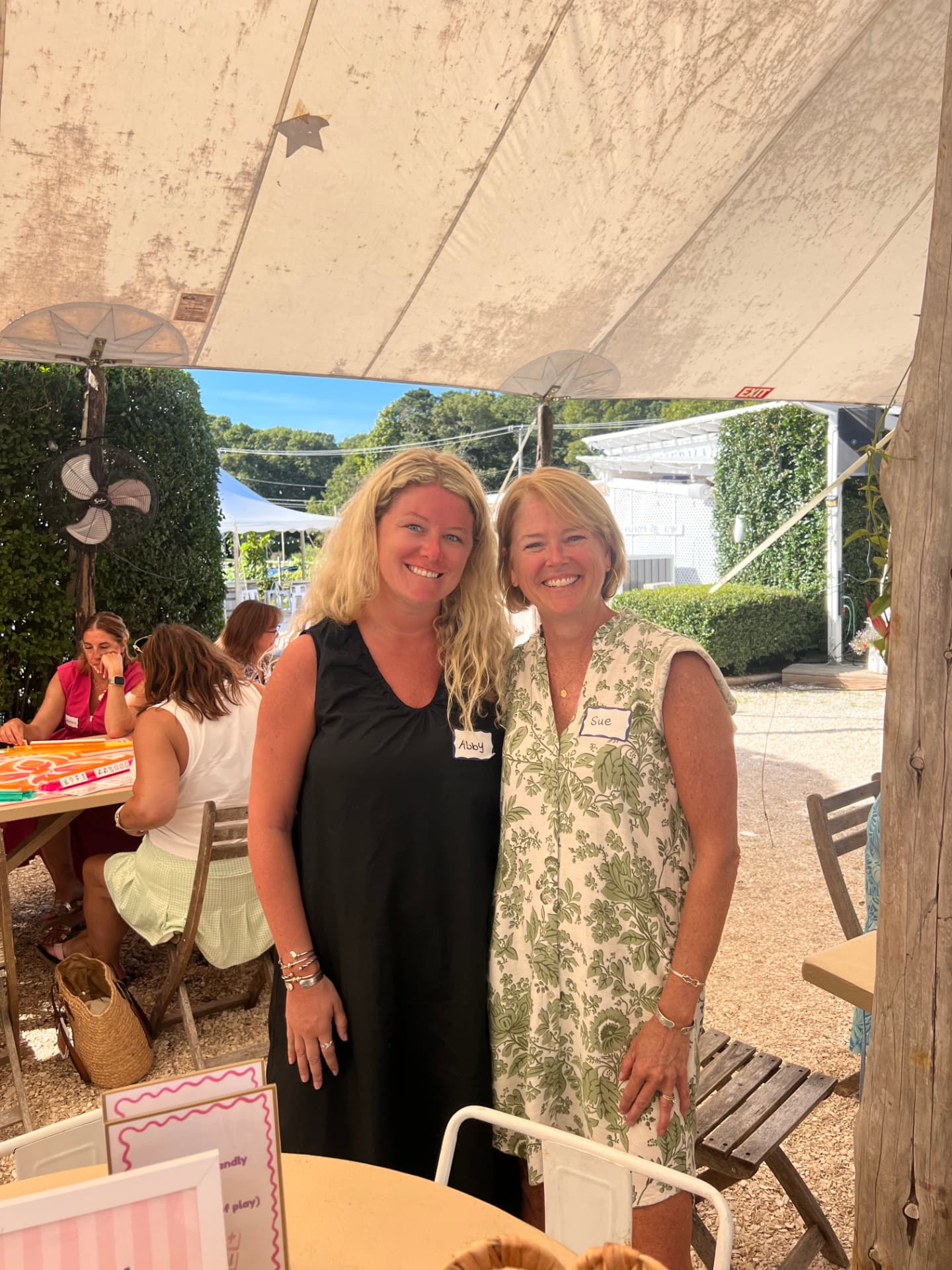 Sue and her daughter Abby at an outdoor Mahjong event under a tent