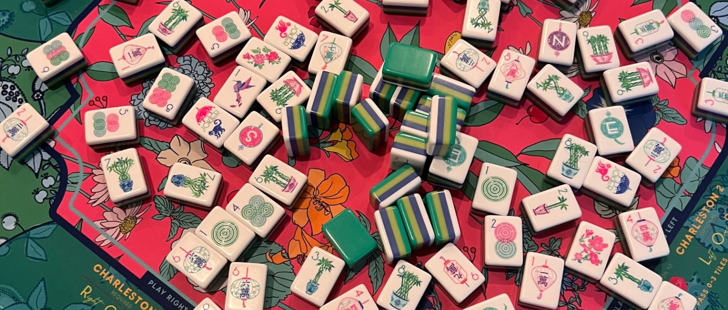 Mahjong tiles spread across a green and pink floral play mat